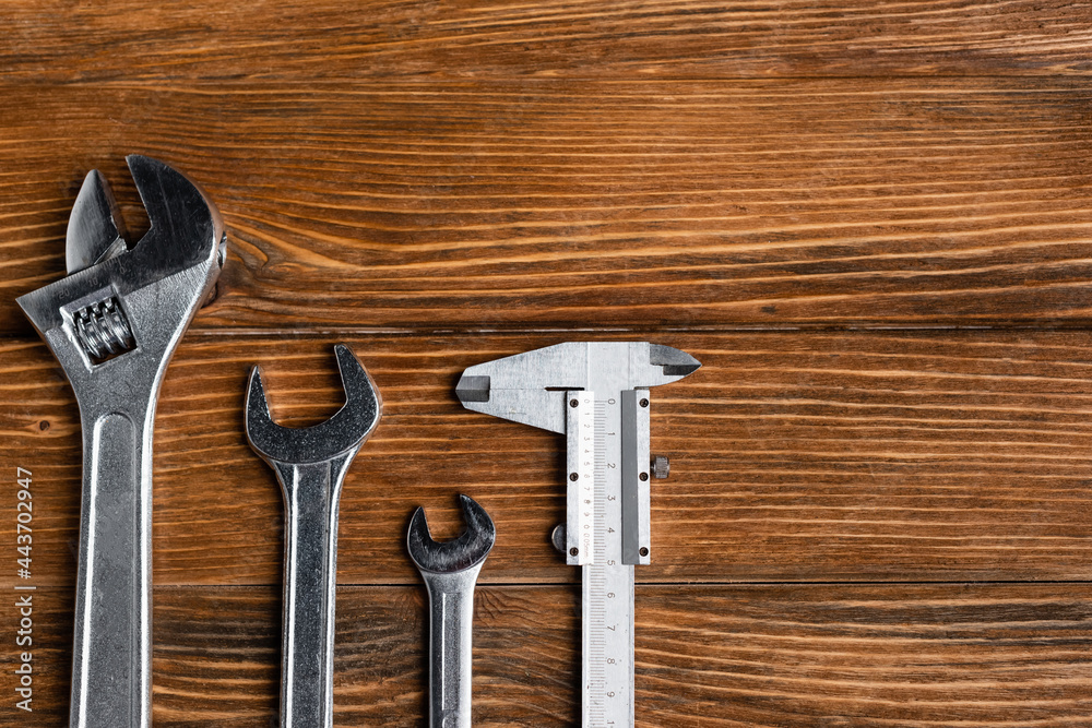 top view of different wrenches and calipers on wooden table, labor day concept top view of different wrenches and calipers on wooden table, labor day concept