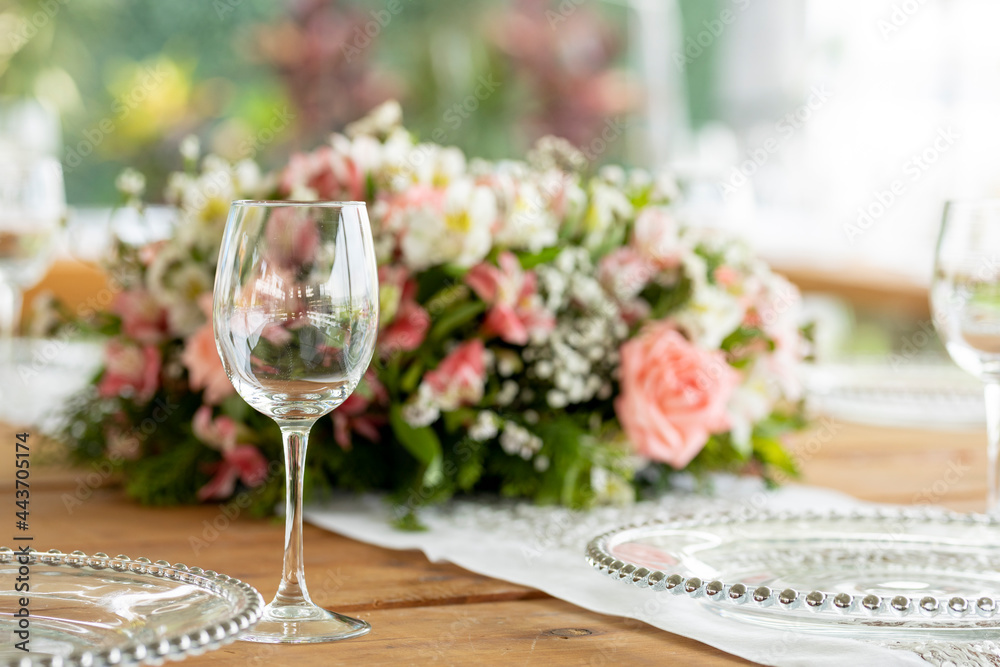 Copa de cristal sobre una mesa con un arreglo floral en una jardín para un evento social en México 