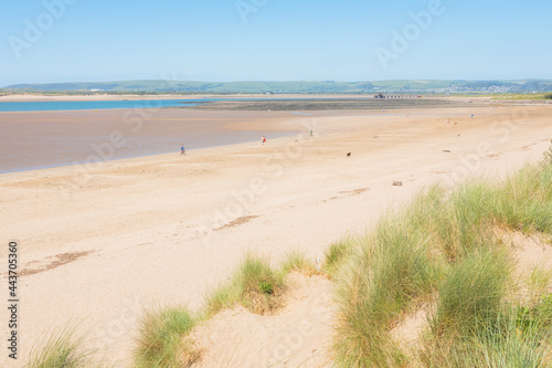 Tourists and locals enjoy the sandy Instow beach on a sunny summer day in North Devon, England, UK. photo