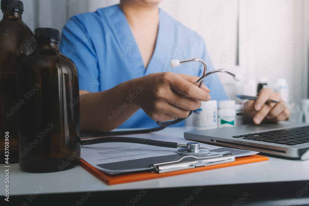 Male doctor sitting at table and writing on a document report in hospital office. Medical healthcare staff and doctor service. Male doctor sitting at table and writing on a document report in hospital office. Medical healthcare staff and doctor service.
