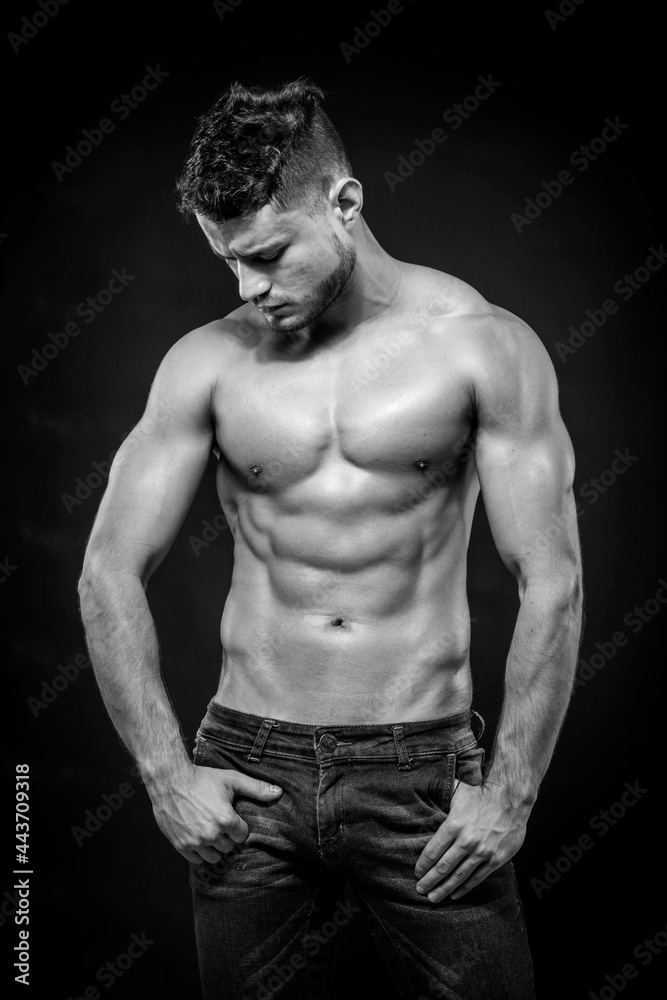 Obraz premium Young strong man on dark background