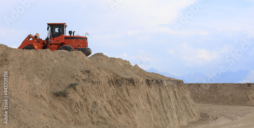 excavator digs the ground in summer