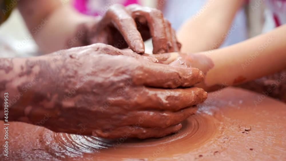 A close-up view on ceramic production process on potter's wheel with children. Clay crafts with kids concept A close-up view on ceramic production process on potter's wheel with children. Clay crafts with kids concept