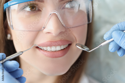 Dentist holding dental instruments in front of woman face