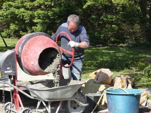 travailleur indépendant qui prépare du béton avec une bétonnière pour maçonnerie  et rénovations