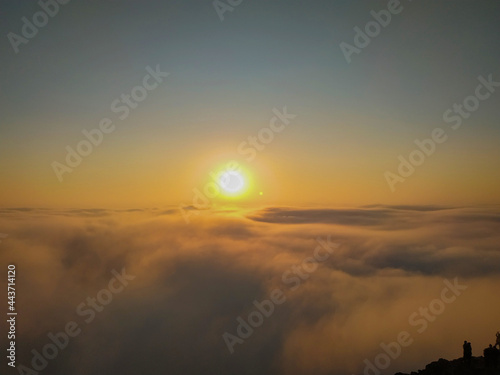 The sun shining above the clouds on a cliff © Gregory gl