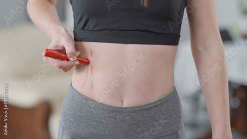 Tummy of slim Caucasian young woman marking waist line with red marker. Unrecognizable fit millennial striving for anorexia. Social pressure and femininity concept