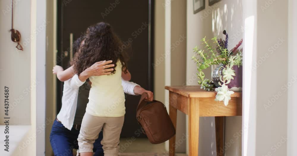 Mixed race mother and daughter gardening in sunny garden,taking care with plants Mixed race mother and daughter gardening in sunny garden,taking care with plants