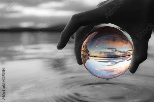 Sunset Reflection in Glass Ball above Lake photo