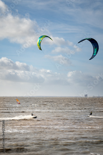 Unknown kitesurfers surf on brown water with waves from the Atlantic Ocean in La Rochelle, France. photo