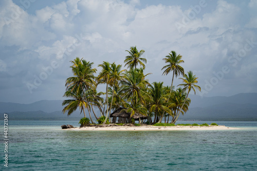Tiny tropical, uninhabited island with coconut palm trees and white sand beach. Vacation and travel concept 