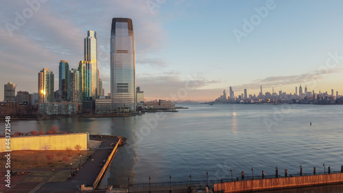 Aerial of New Jersey skyscrapers on the Hudson River across from Manhattan with a 911 memorial in the foreground.