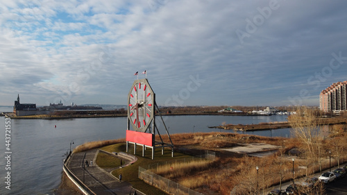 Large clock with the Statue of Liberty and Ellis Island in the background, overlooking the Hudson River from New Jersey.