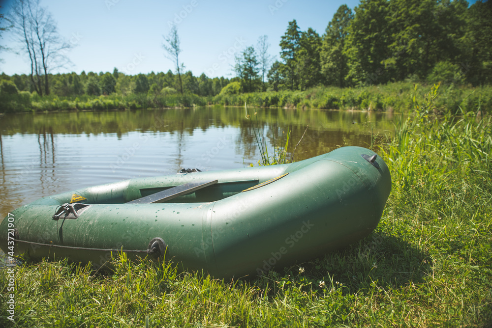 Rubber boat with fishing gear standing on a river near the sandy beach. Rubber boat with fishing gear standing on a river near the sandy beach.