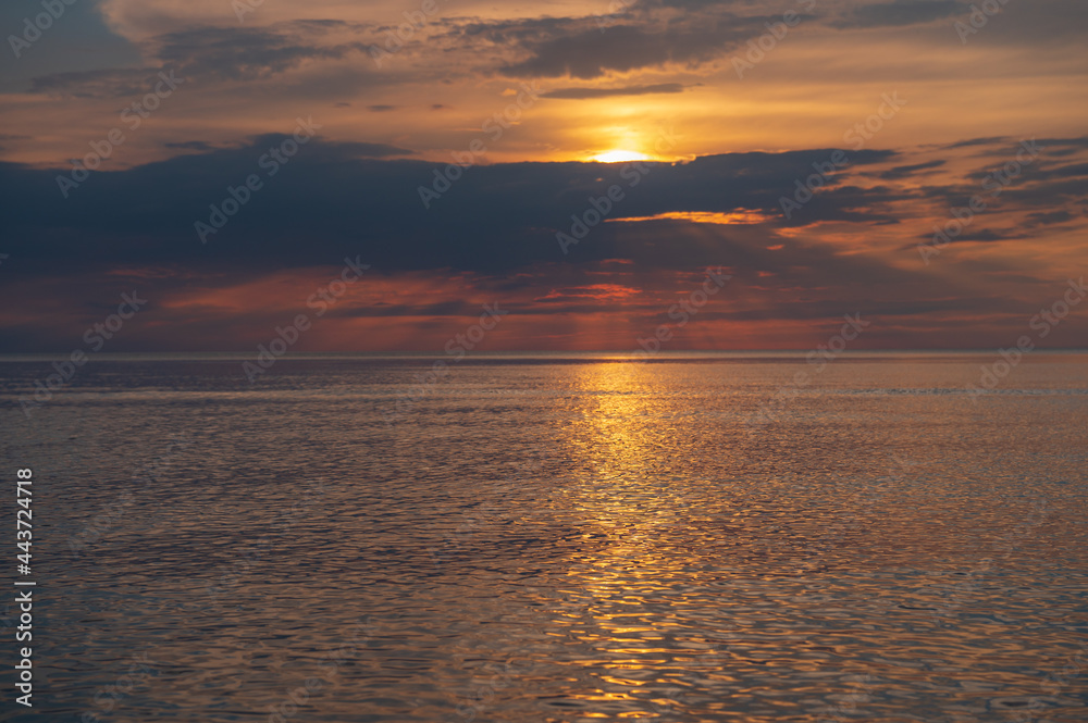 Obraz premium sunset in the sea with clouds and calm water