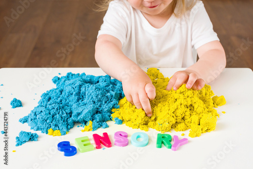 Little girl playing with magic kinetic sand, Sensory word. Early sensory education. Kidd's sensory experiences, games for fine motor skills. Therapy hand, development of fine motor photo