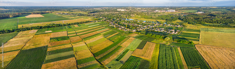 European wide panorama with many fields on the countryside and little town near