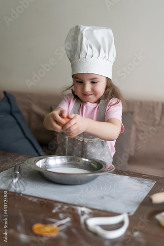 Cooking cute little girl with an egg