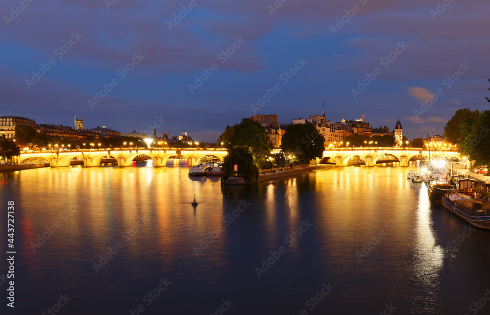CItyscape of downtown with Pont Neuf Bridge and River Seine at night , Paris .