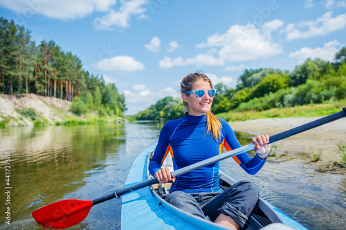 Happy family kayaking on the river on a sunny day during summer vacation