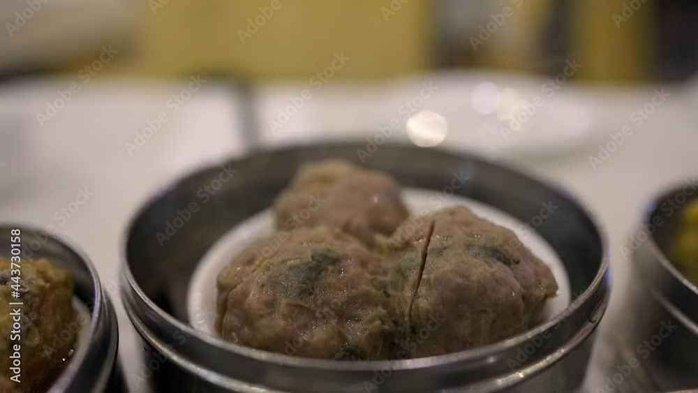 This close up video shows a hot and fresh dim sum meatball dish giving off steam. This close up video shows a hot and fresh dim sum meatball dish giving off steam.