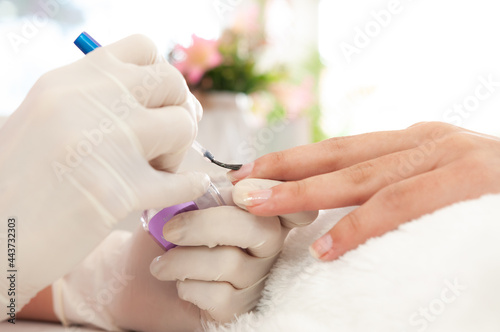 professional manicurist s hands painting nails with nail polish  vanity concept