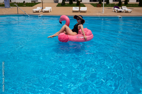 Beautiful woman on flamingo pool float in pool. Summer holidays © Marharyta