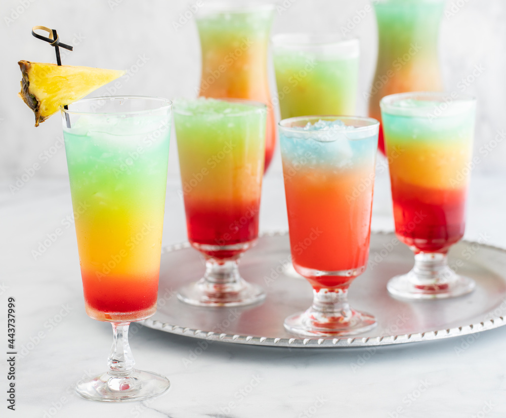 A tray of frosty colourful mocktails with one garnished mocktail in front.