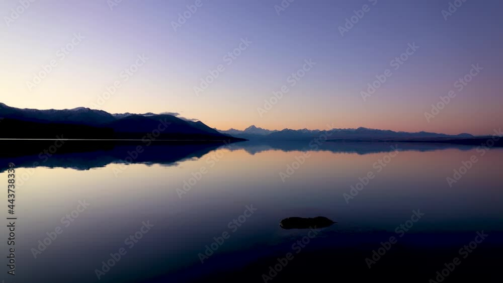 Super Wide sunset time lapse of Mount Cook and Lake Pukaki with reflections of bright clear mountain skyline. Mount Cook National park, Lake Pukaki, Mackenzie country, New Zealand Super Wide sunset time lapse of Mount Cook and Lake Pukaki with reflections of bright clear mountain skyline. Mount Cook National park, Lake Pukaki, Mackenzie country, New Zealand