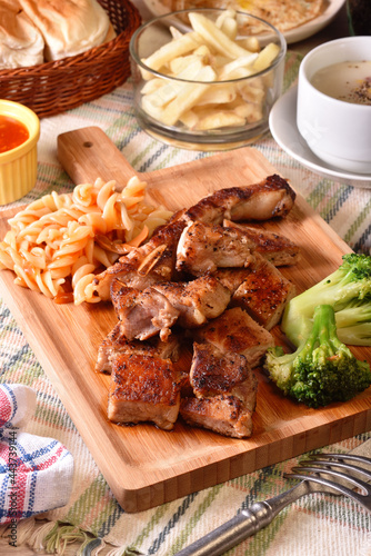 Grilled bone-in pork chop on wooden board 