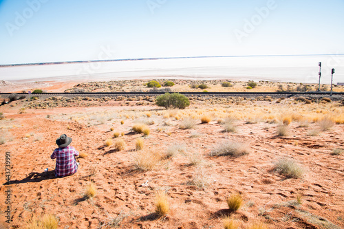 Women wearing Akubra sitting having a cup of coffee waiting for the trains to pass on the salt plains in South Australian desert.