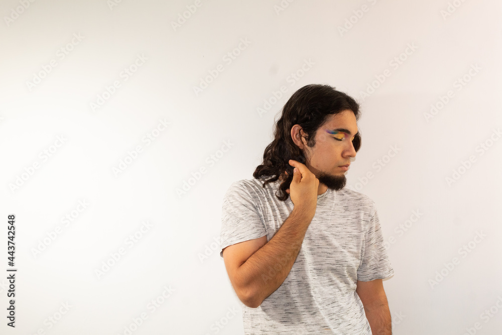 portrait of a gay man made up with a rainbow in his eyes on a white background with a serious face portrait of a gay man made up with a rainbow in his eyes on a white background with a serious face