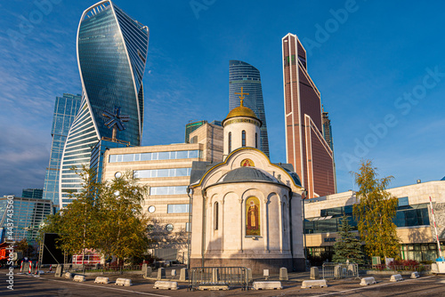 A small orthodox church in front of modern towers in Moscow City, Russia