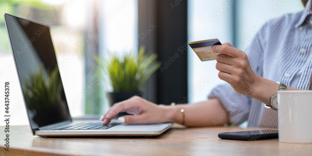 Online payment,Young woman's hands using computer and hand holding credit card for online shopping Online payment,Young woman's hands using computer and hand holding credit card for online shopping