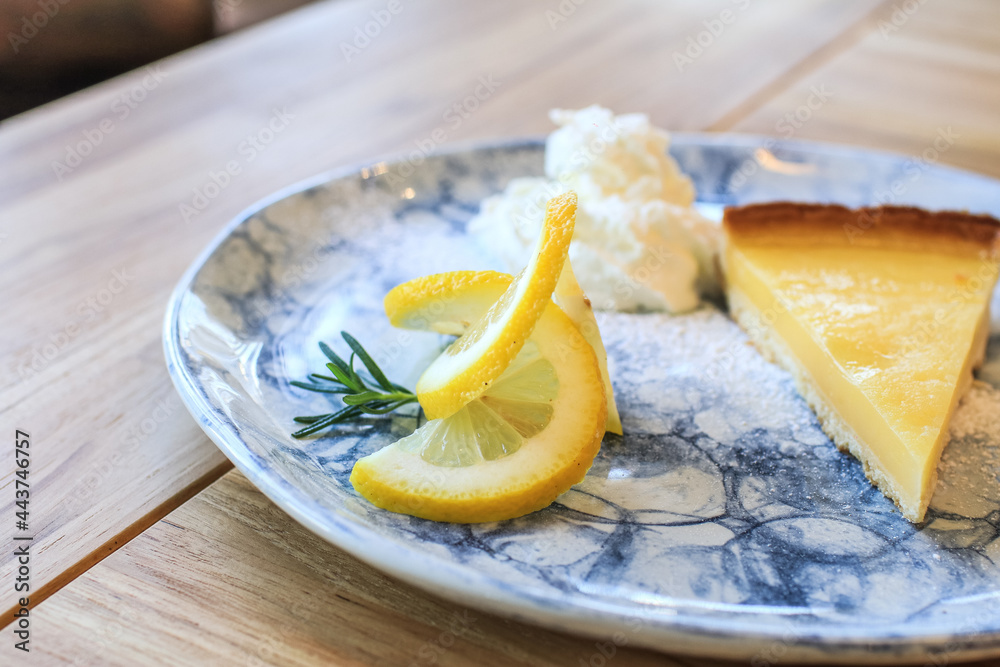 Lemon tart with slice of lemons. Enjoy fresh baked dessert in restaurant. Closeup shot of little sweet decorative cake Lemon tart with slice of lemons. Enjoy fresh baked dessert in restaurant. Closeup shot of little sweet decorative cake