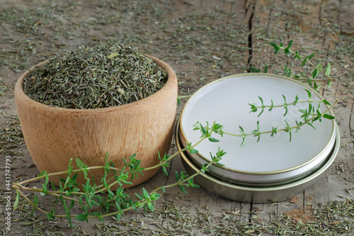 Thyme oinment and dried thyme on a bowl over a wooden table photo