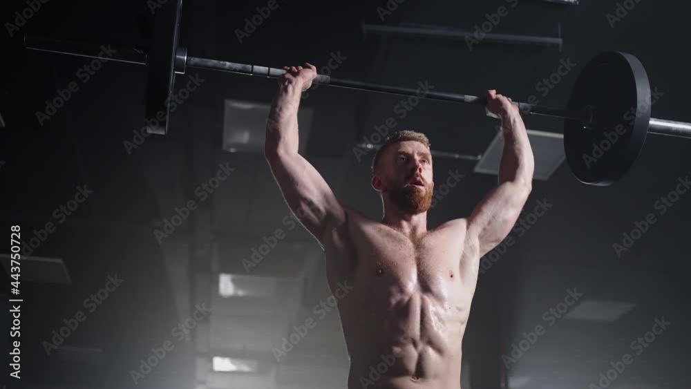 Slow motion of crossfit athlete performs clean and jerk. Young man doing the clean and jerk weightlifting exercise at the gym. Slow motion of crossfit athlete performs clean and jerk. Young man doing the clean and jerk weightlifting exercise at the gym.