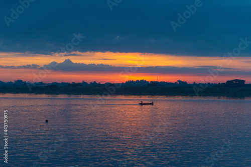 The sunrise view on the Mekong River overlooks the Laos side and sees fishermen driving their fishing boats at dawn.