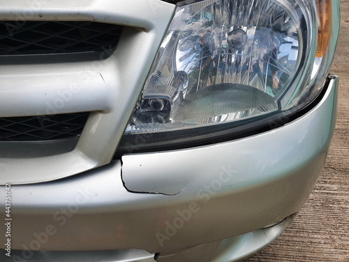 The gray pickup truck's lights and front bumper cracked and fell out of place due to a serious accident or the use of low-quality materials. Is made of polyurethane or fiber-reinforced plastic,
 photo