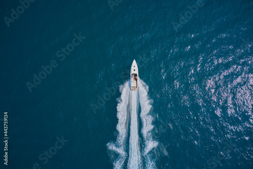 Speedboat wave speed water. Speed boat faster movement on the water top view. Speedboat movement on the water. Large white boat driving on dark water. Speedboat on blue water aerial view.