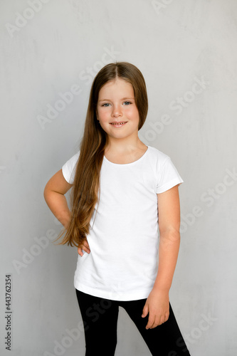 Cute young child with long hair in white t-shirt and black sweatpants