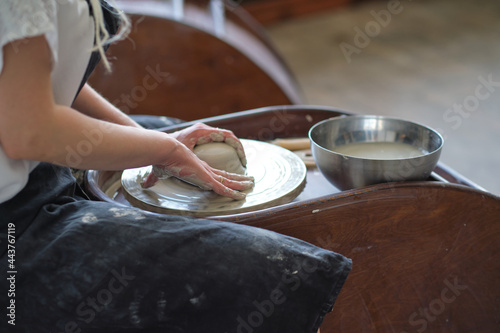 Female Potter creating a earthen jar on a Potter s wheel