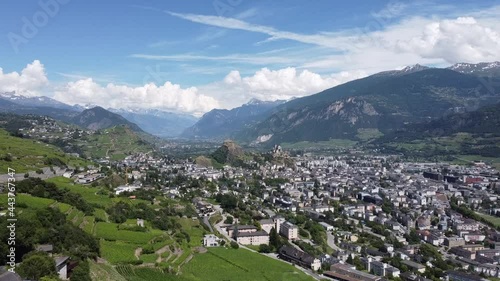 View from a drone of the beautiful city of Sion in the mountains in southern Switzerland, beautiful sunny weather with some clouds in the sky photo