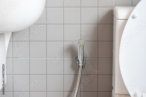 Chromium bidet shower with grey ceramic tile in toilet. silver bidet spray shower. photo