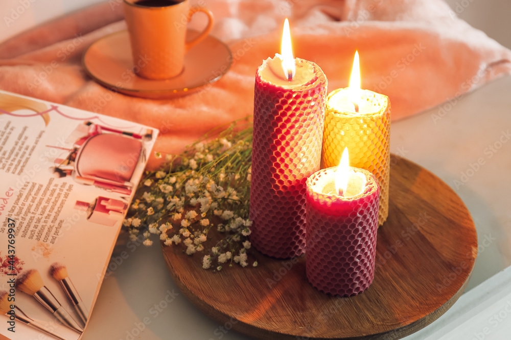 Burning candles, cup of coffee and magazine on table Burning candles, cup of coffee and magazine on table