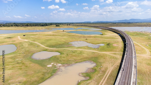 Aerial Unseen view of railroad tracks of floating Train bridge with white car in Khok Salung, Pa Sak Jolasid dam Lopburi amazing Thailand, Known as a floating train route. photo