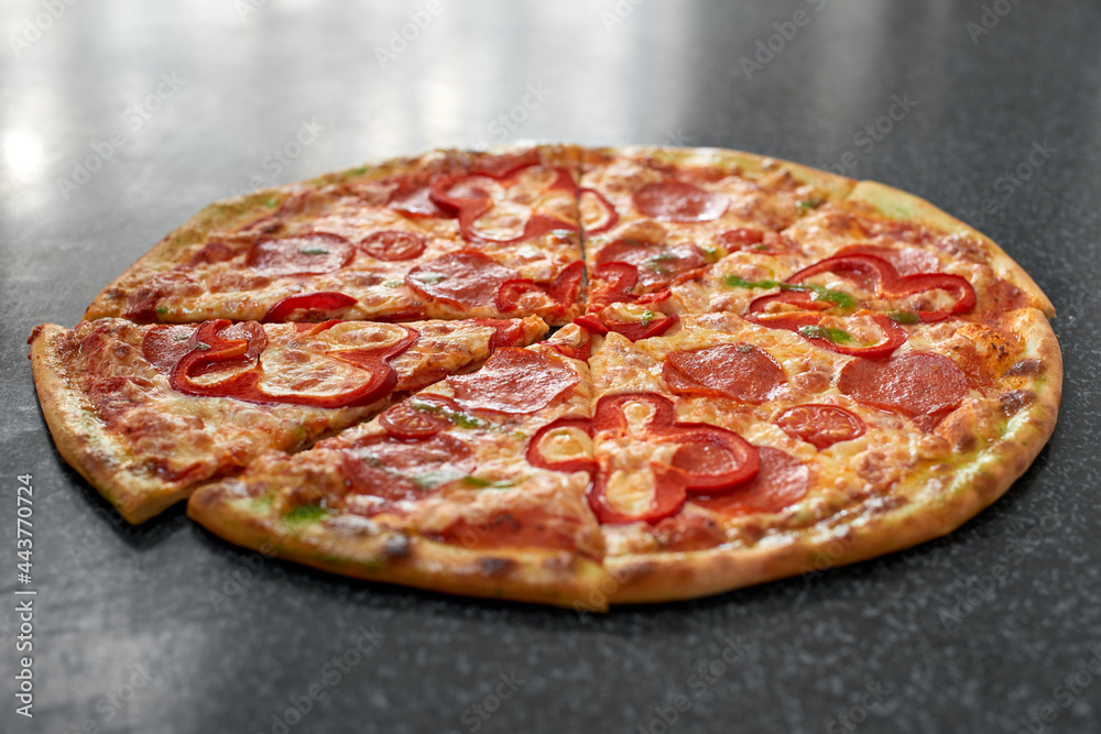 Delicious pizza with salami, red pepper and tomatoes