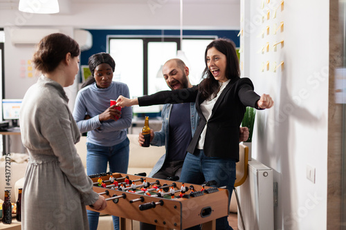 Fotografi Cheerful team of multi ethnic colleagues enjoy foosball table game football soccer