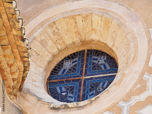 óculo circular de piedra color marrón y cristalera con modelos decorativos en tonos azules, perteneciente al santuario de la sierra de montblanch, tarragona, españa, europa photo