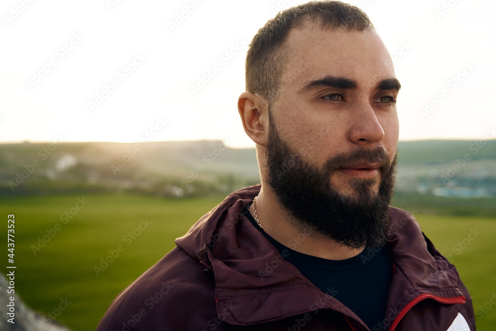 Fototapeta premium Young bearded man portrait outdoors in the mountains